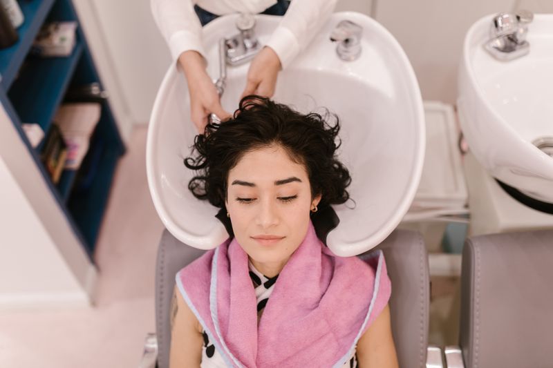 Relaxed client at the shampoo bowl with towel