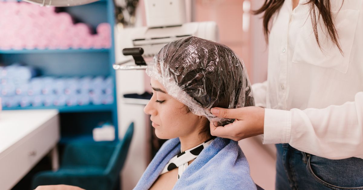 Client with hair treatment cap at the salon