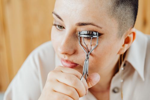 Woman using an eyelash curler, close-up
